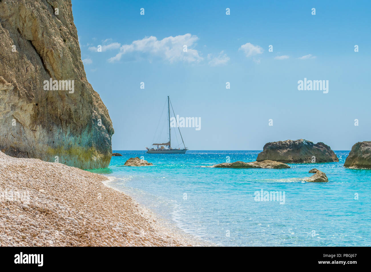 A boat is sailing into the turquoise sea waters of Porto katsiki in Lefkada Ionian island in Greece Stock Photo
