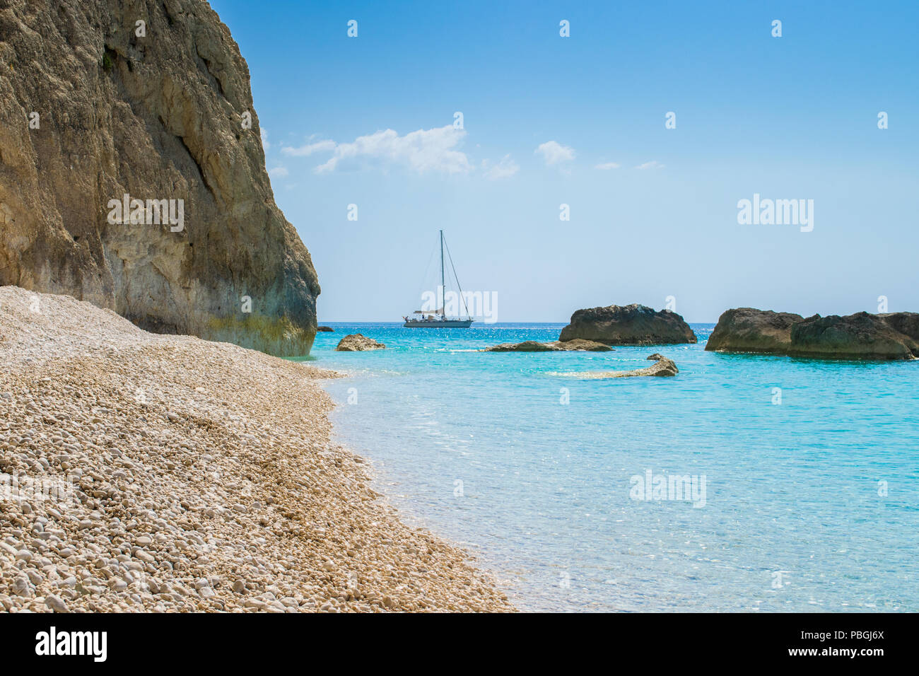 A boat is sailing into the turquoise sea waters of Porto katsiki in Lefkada Ionian island in Greece Stock Photo