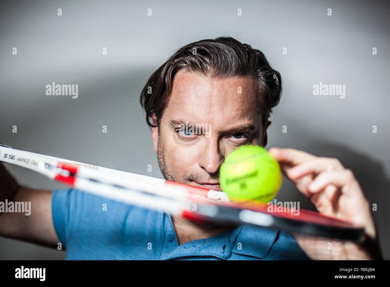 Man Using Tennis Racket portrait of a handsome man with a tennis racket Stock Photo - Alamy