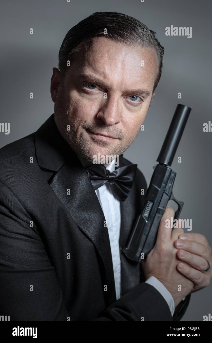 portrait of a handsome man holding a gun Stock Photo