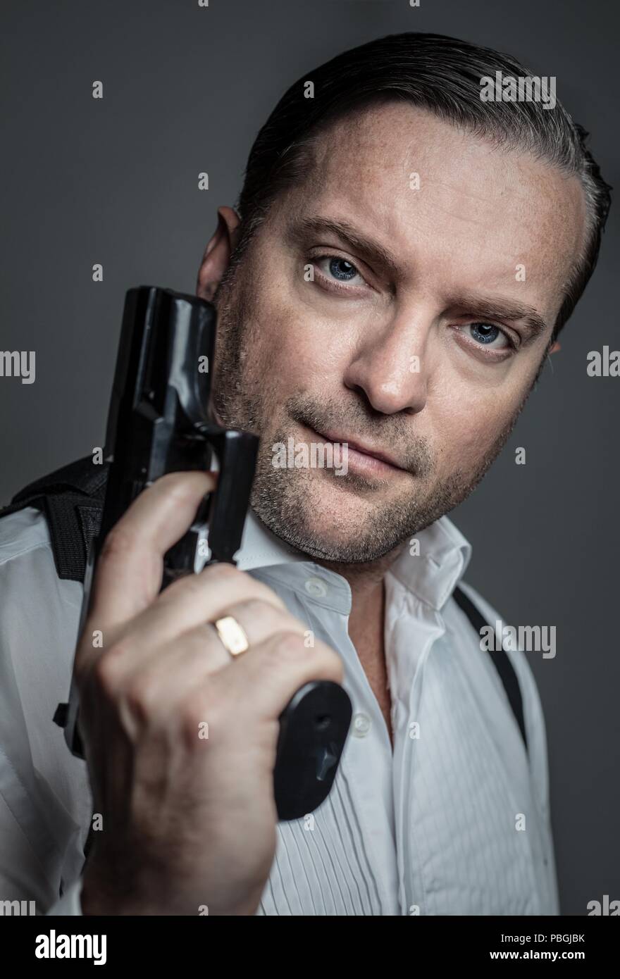 portrait of a handsome man holding a gun Stock Photo