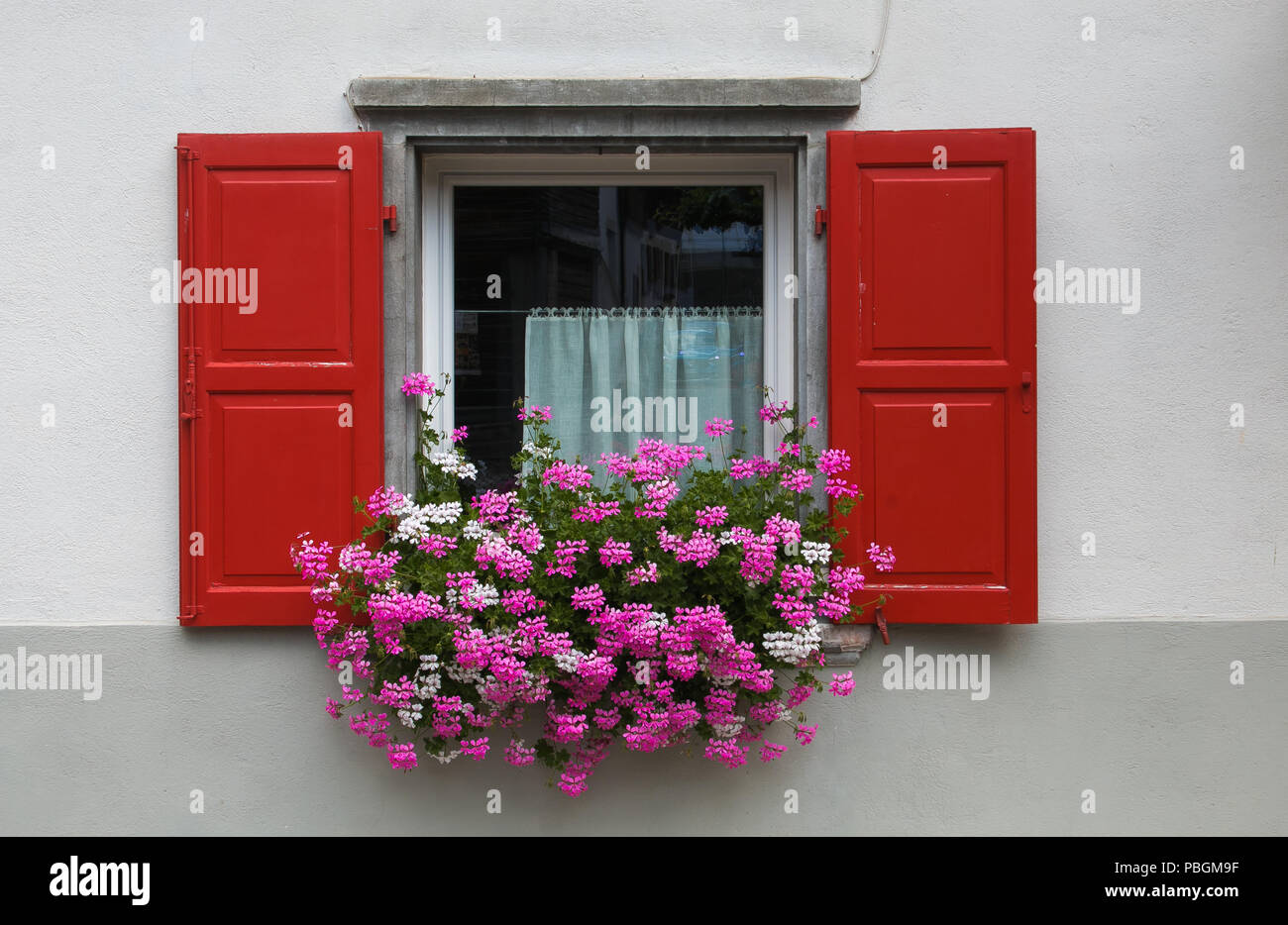 Window decorated with pink and white geranium flowers Stock Photo