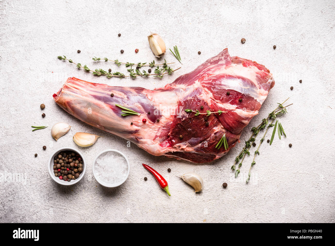 Raw fresh Lamb Meat shank and seasonings on a gray concrete background Stock Photo