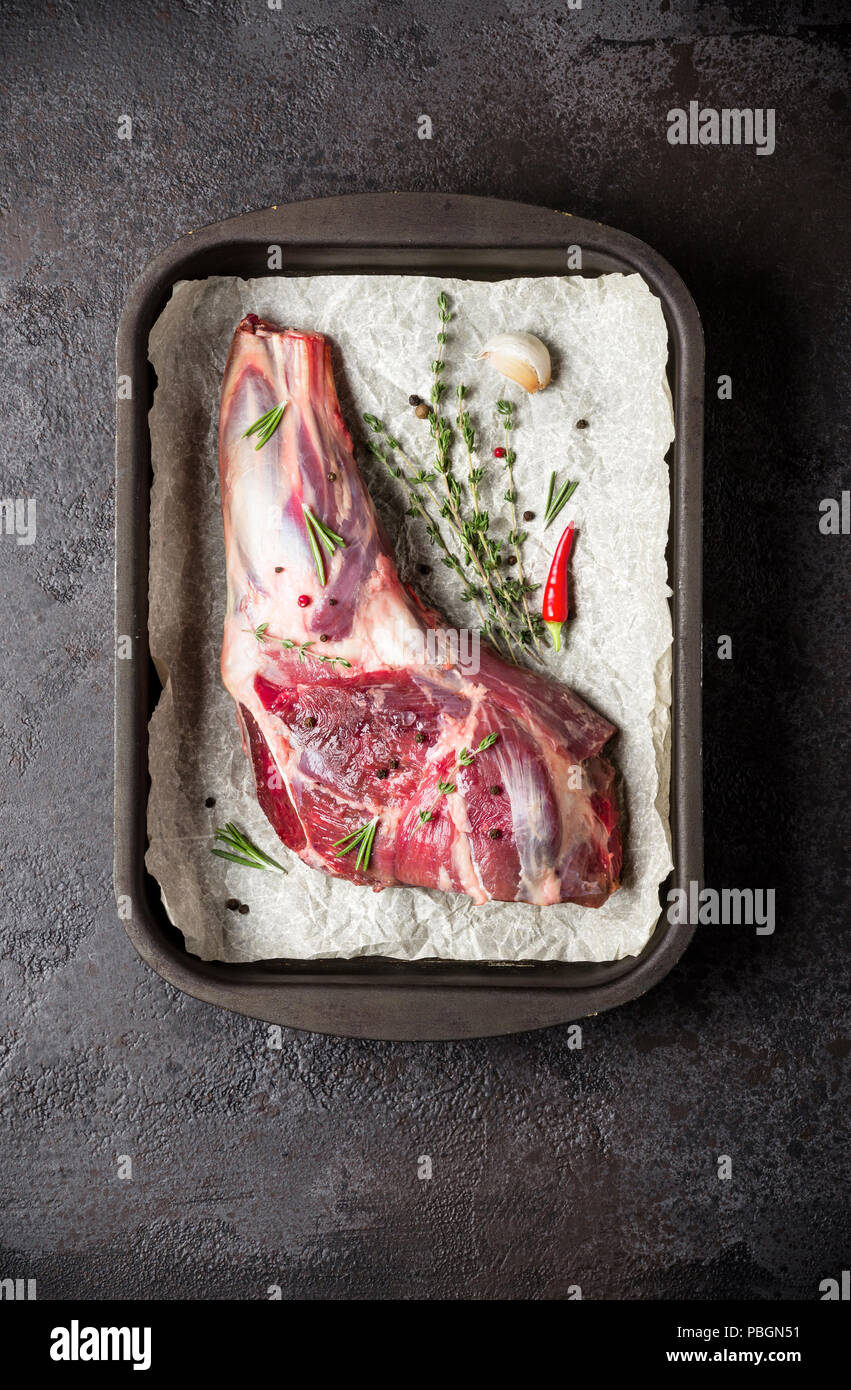 Raw fresh Lamb Meat in baking tray, herbs and spice. Stock Photo
