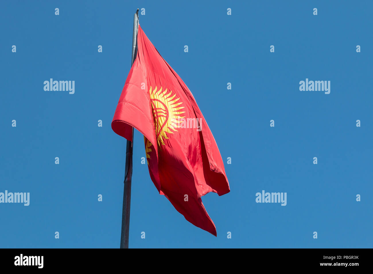 Flag of Kyrgyzstan, featuring a red background and a yellow sun, flying over  Ala Too Square in central Bishkek, the country's capital city Stock Photo -  Alamy