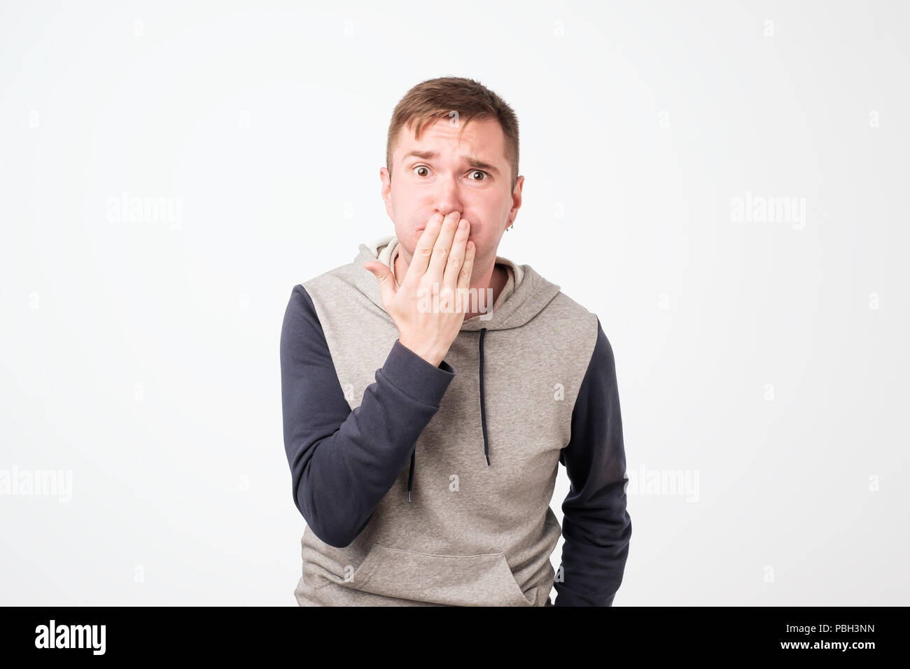 Nausea aversion repulsion. European young handsome man grimacing in disgust. Stock Photo