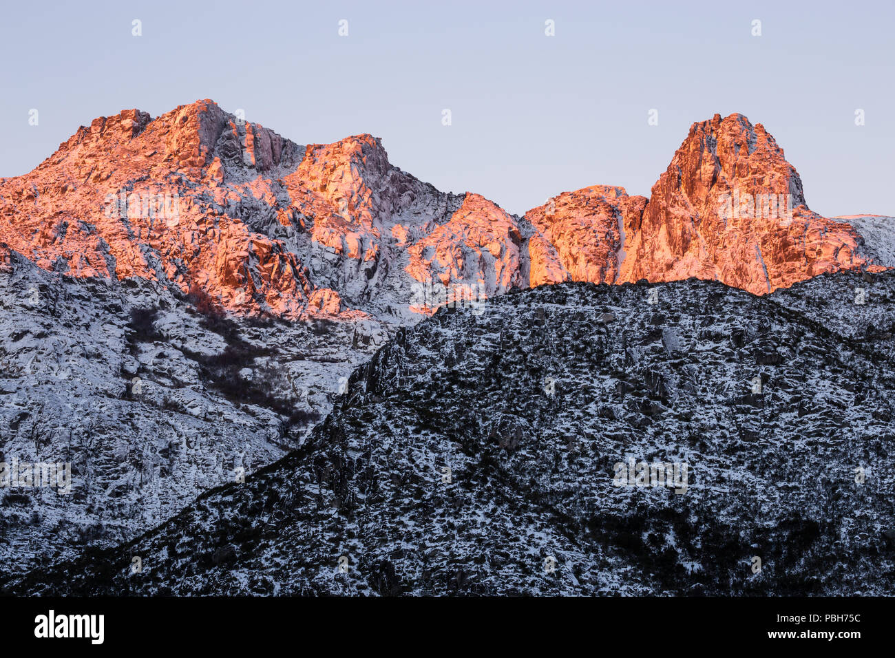 Cantaro Magro, on the right, catches the sunrise before the rest of the valley becomes sunlit. Covao d'Ametade, Zezere glacial valley, Serra da Estrel Stock Photo