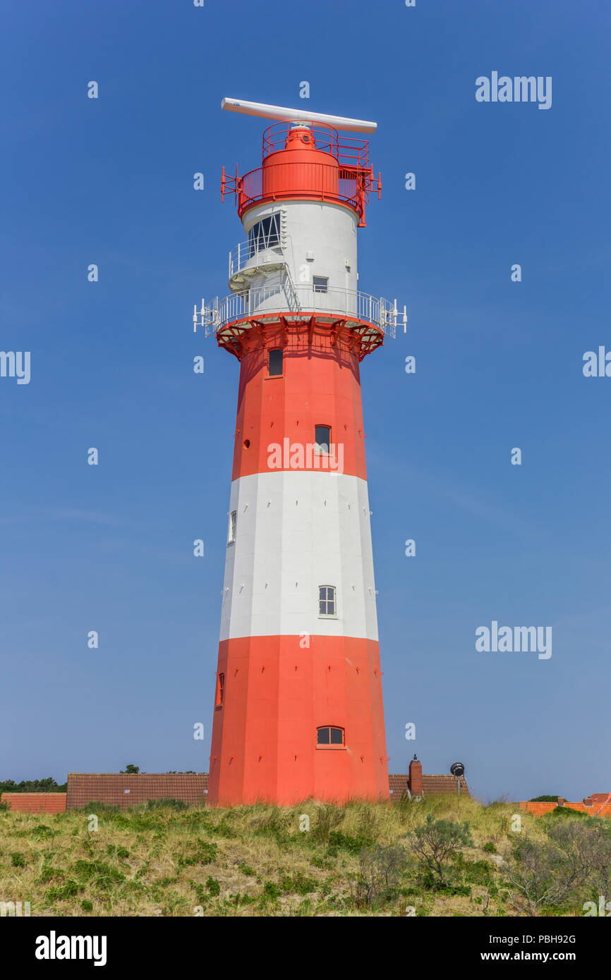 Red and white lighthouse in the dunes of Borkum, Germany Stock Photo