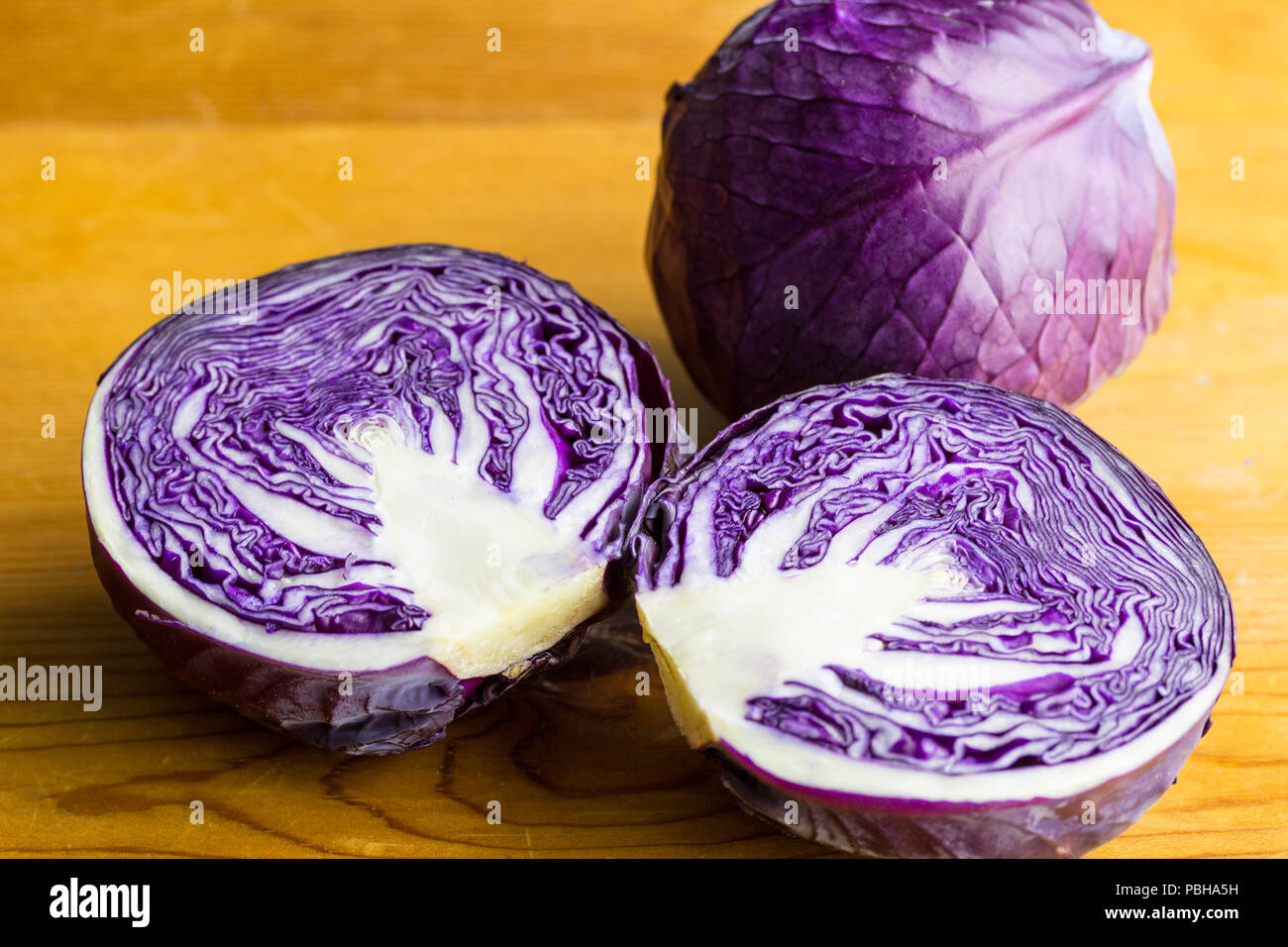 Purple cabbage isolated on wooden table close up Stock Photo
