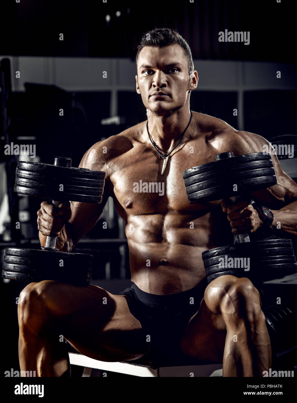 very power guy - bodybuilder, execute exercise with weight, inside gym, vertical photo Stock Photo