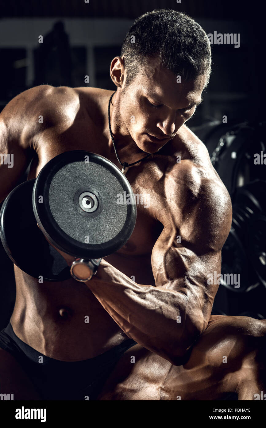 very power guy - bodybuilder, execute exercise with weight, inside gym, vertical photo Stock Photo