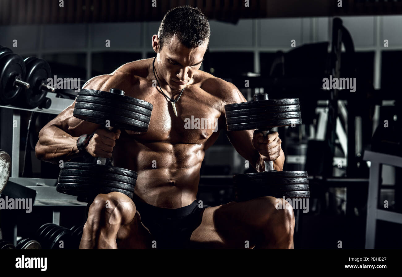 very power guy - bodybuilder, execute exercise with weight, inside gym, horizontal photo Stock Photo