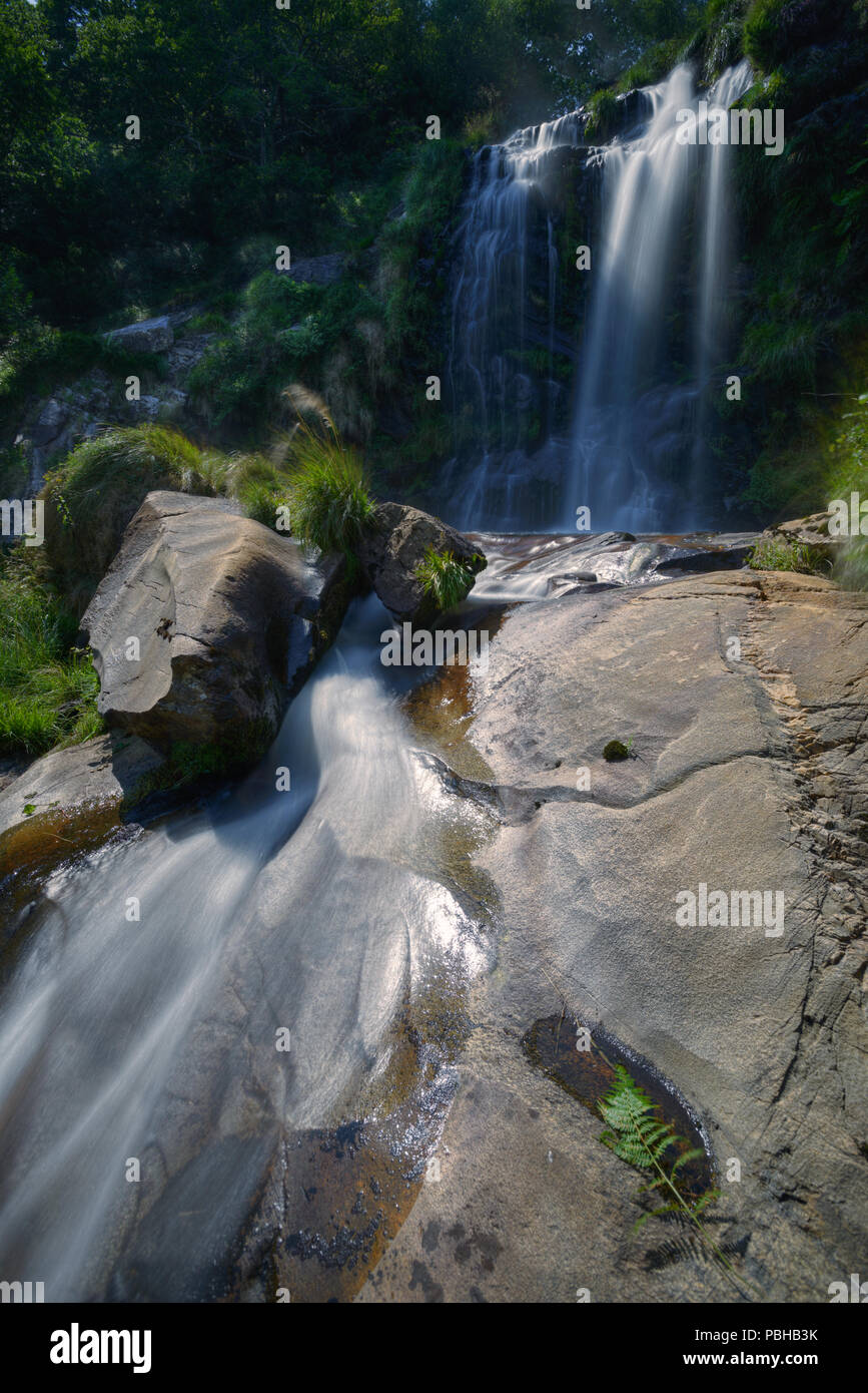 Rocas graníticas pulidas por el agua de un arroyo y cascada Stock Photo