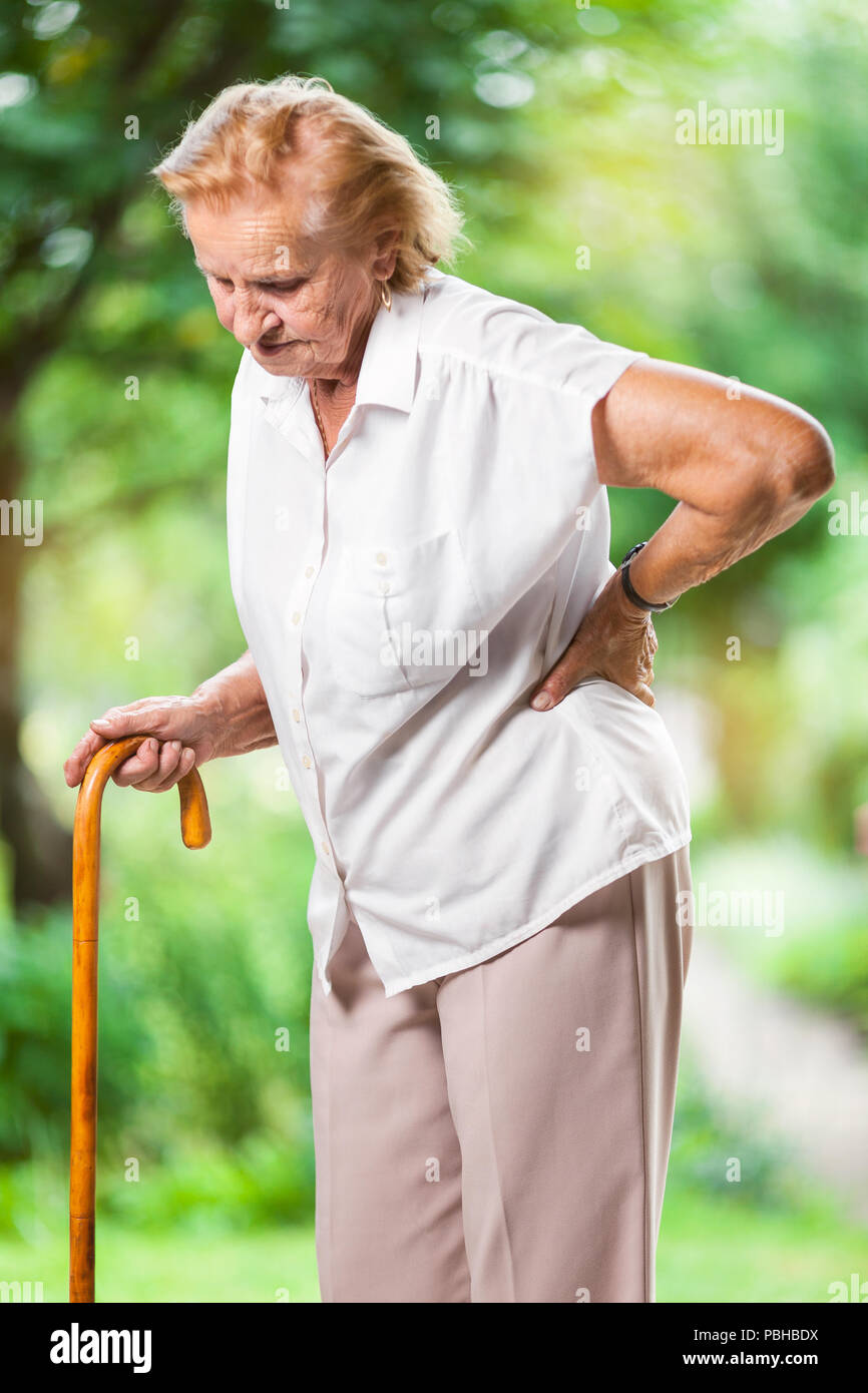 Elderly woman outdoors with lower back pain Stock Photo Alamy