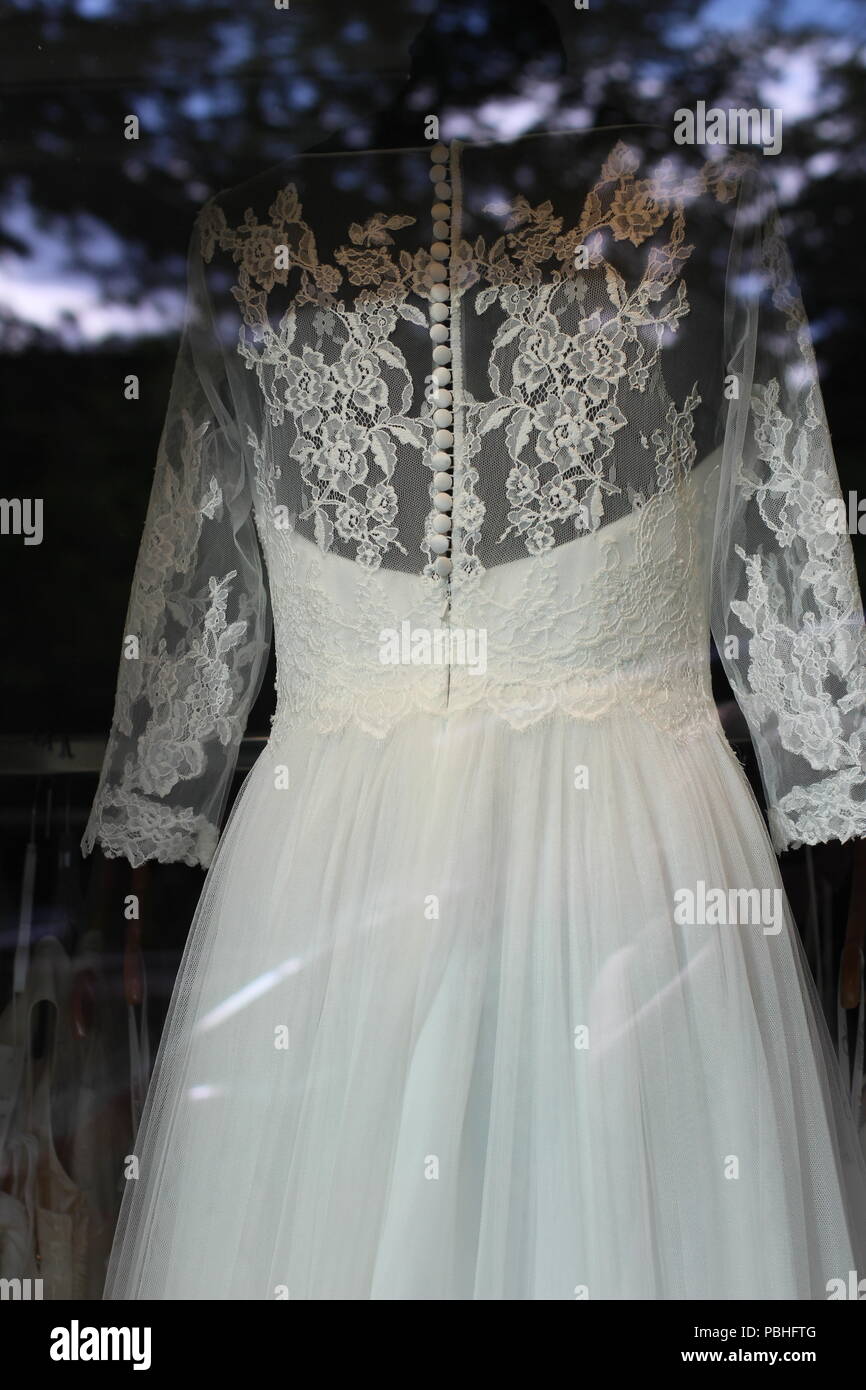Wedding dress with lace and buttons in shop window Stock Photo