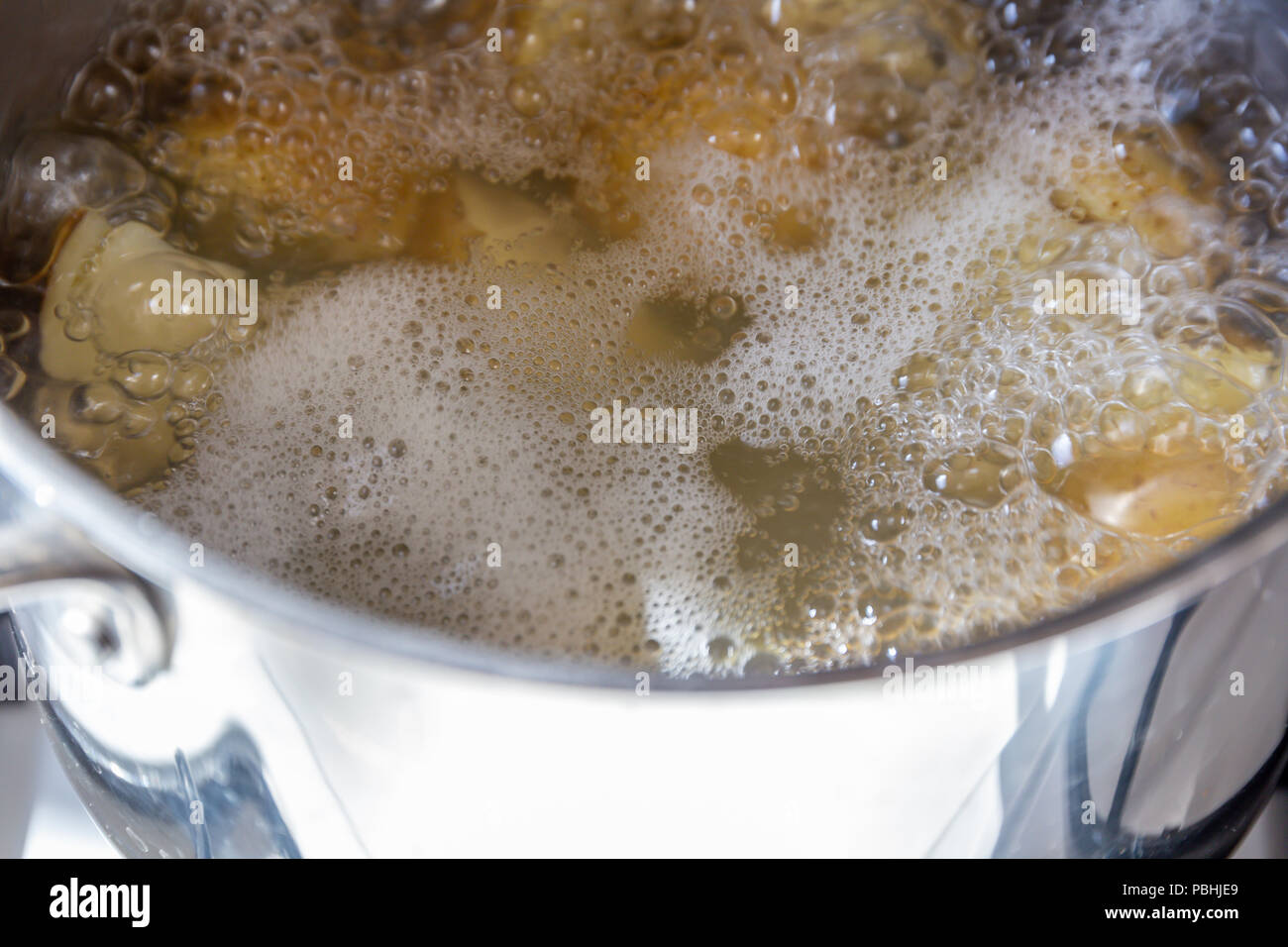 Pan of potatoes cooking in boiling water Stock Photo