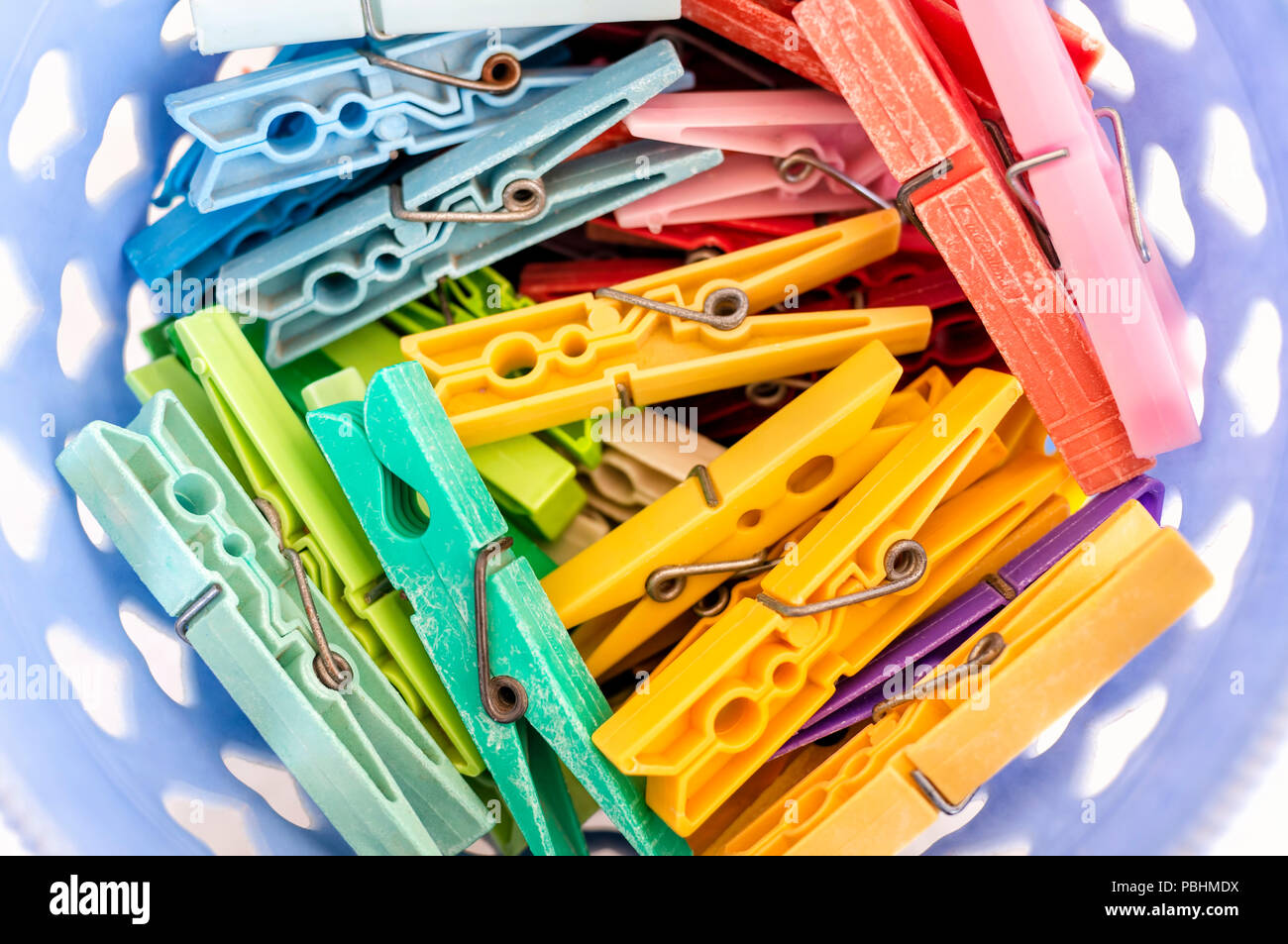 Laundry Basket Filled With Colorful Clothes Pegs Stock Photo