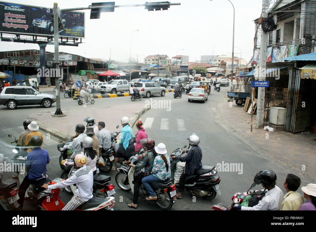 Busy Street Scene with Motorbikes and Cars, Phnom Penh, Cambodia Stock Photo