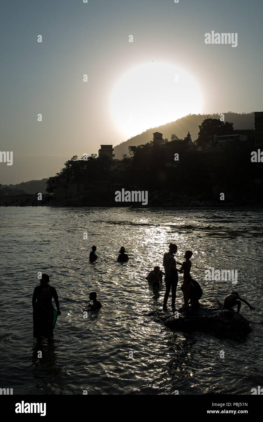 People bathe in the holy Ganges river at sunset, Rishikesh, India, Asia Stock Photo