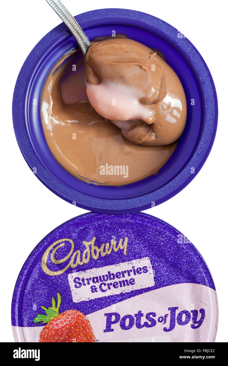 getting ready to eat with a spoonful of Cadbury Strawberries & Crème Pots of Joy set on white background Stock Photo