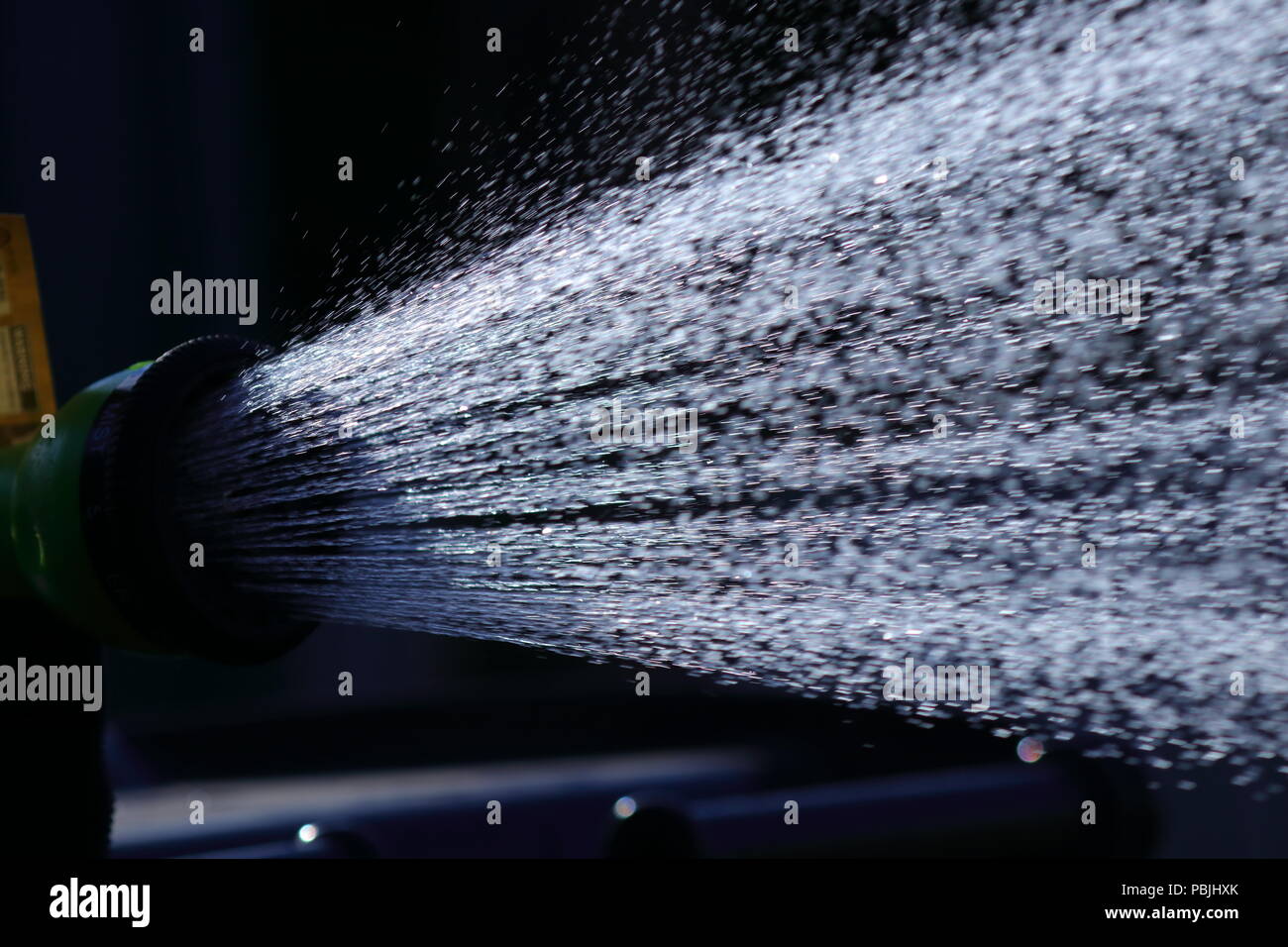 A shower of water from a hosepipe before the proposed hosepipe ban comes into effect. Stock Photo