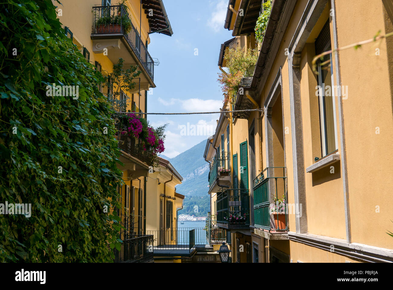 Narrow alley of Bellagio leading to the lake, in the background a glimpse of the lake,Italy Stock Photo