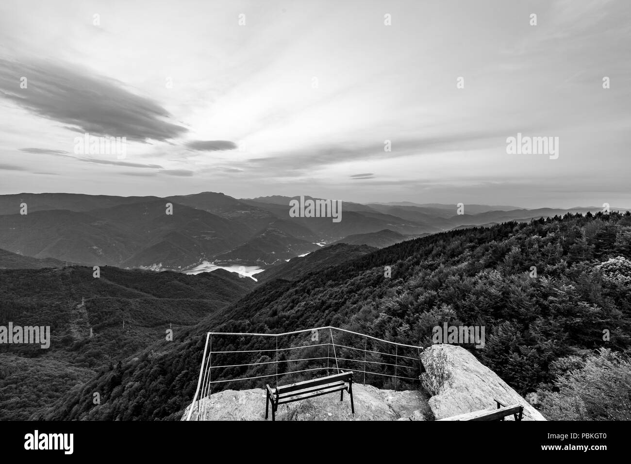 Calm scenery springtime black and white landscape, high altitude observation deck view with picturesque rocks and wooden bench in Rhodope mountain nea Stock Photo