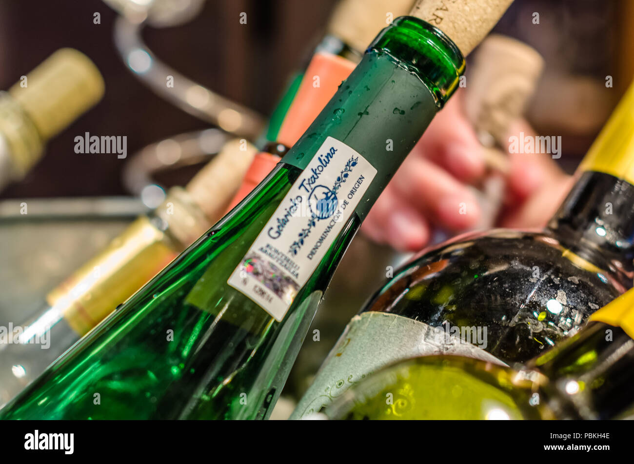 MADRID, SPAIN - AUGUST 27, 2017: Ice bucket with bottles of wine served in a bar in Madrid, highlighting a bottle of txakoli, a Spanish white wine Stock Photo