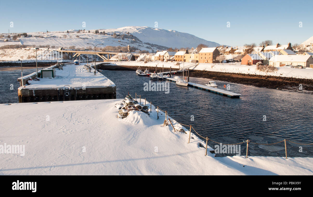 Winter snow lays thick on the breakwaters of Helmsdale Harbour in Sutherland, in the far north of the Highlands of Scotland. Stock Photo