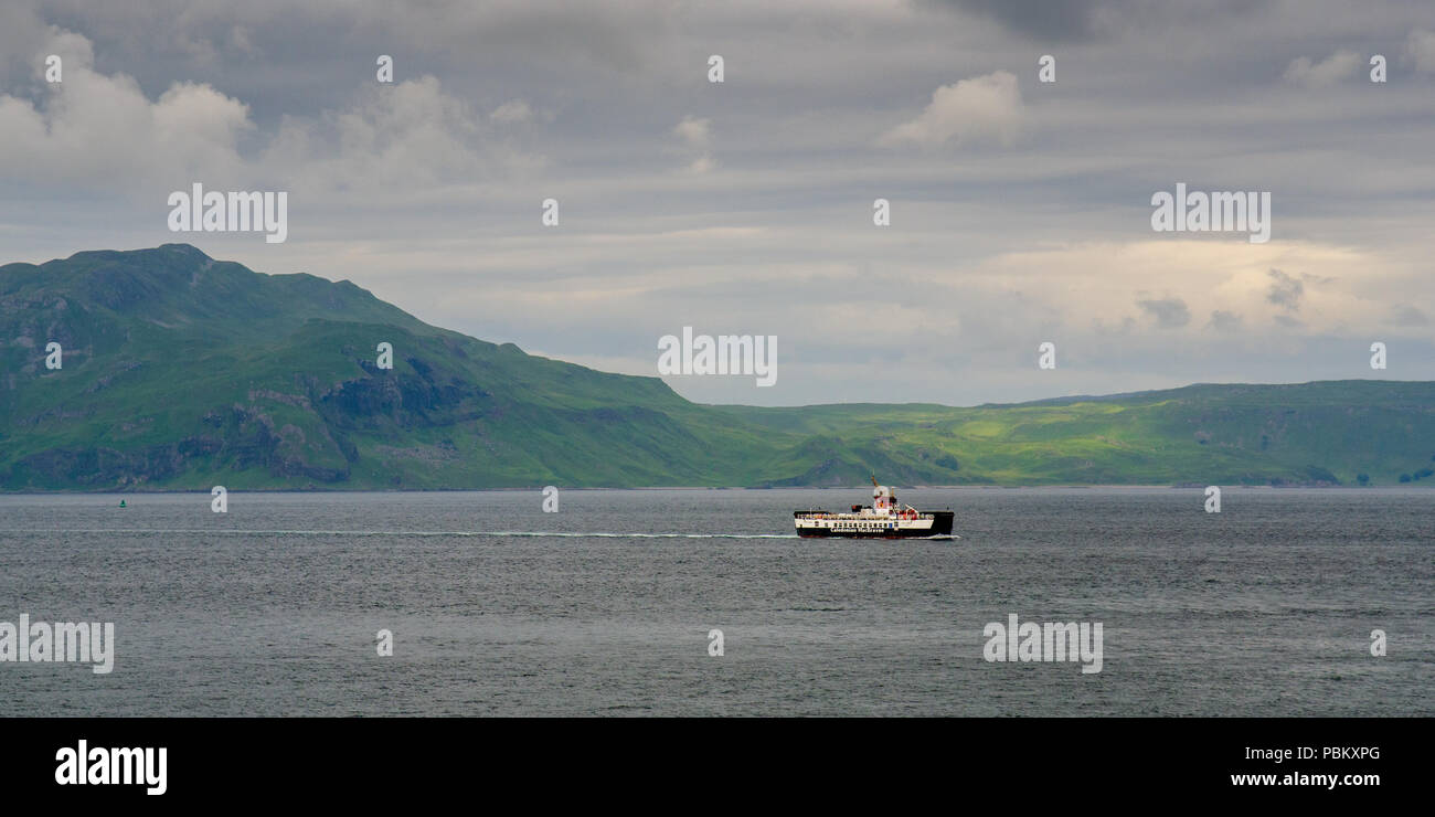 Tobermory, Scotland, UK - June 21, 2014: A Caledonian Macbrayne ferry boat in the Sound of Mull passes mountains of the Ardnamurchan Peninsula in the  Stock Photo