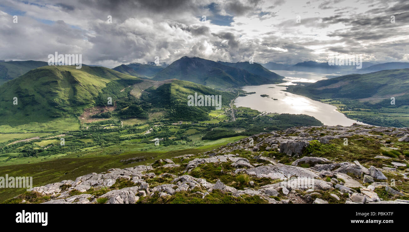Sun reflects of Loch Leven, a sea inlet reaching up to the green valley of Glen Coe under the mountains of the West Highlands of Scotland, seen from t Stock Photo
