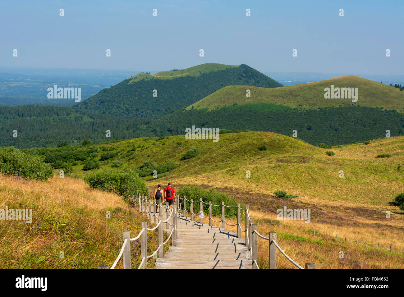 Hikers walking in regional natural park of Auvergne Volcanoes, Unesco ...