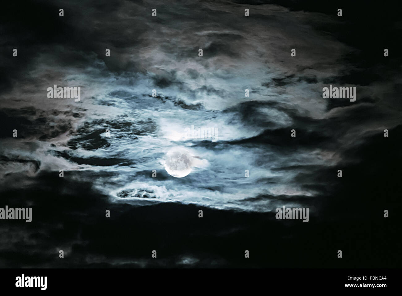 Full Moon Behind The Dramatic Clouds In A Dark Night Sky Stock Photo Alamy