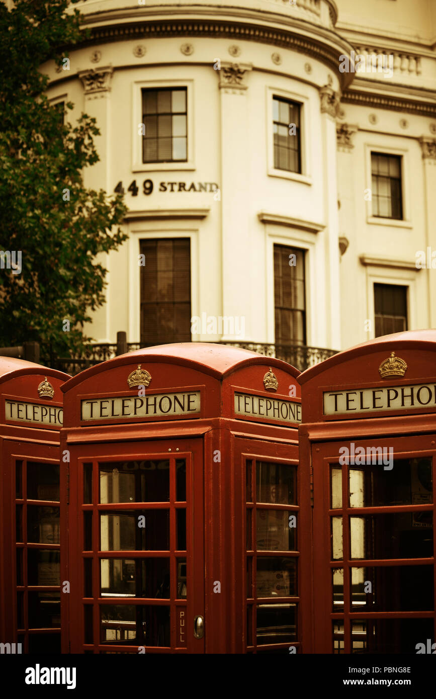 Red telephone box in street with historical architecture in London