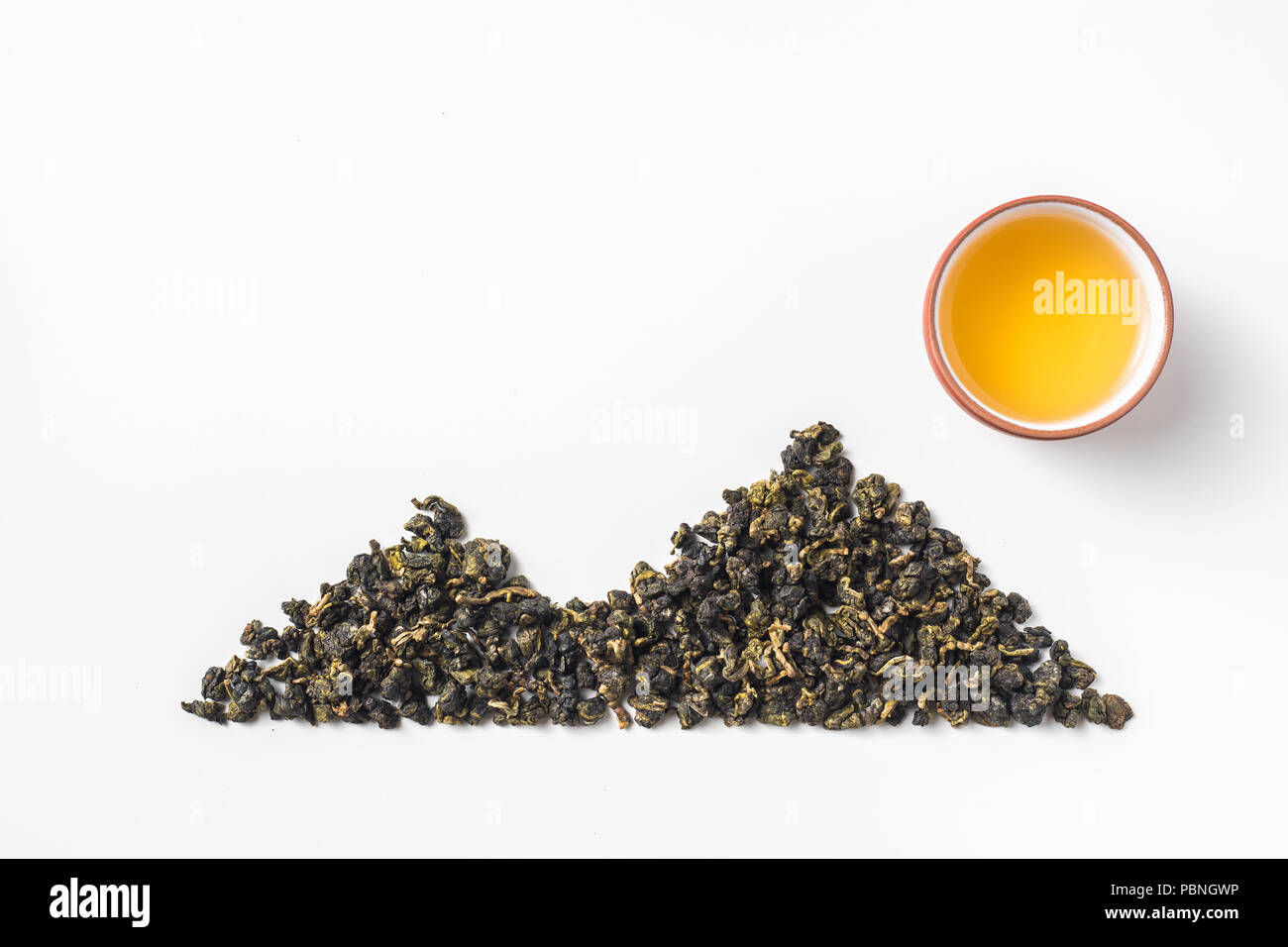 Asia culture and design concept - fresh taiwan oolong tea dry bud and chinese porcelain teacup layout like mountain & sun Stock Photo