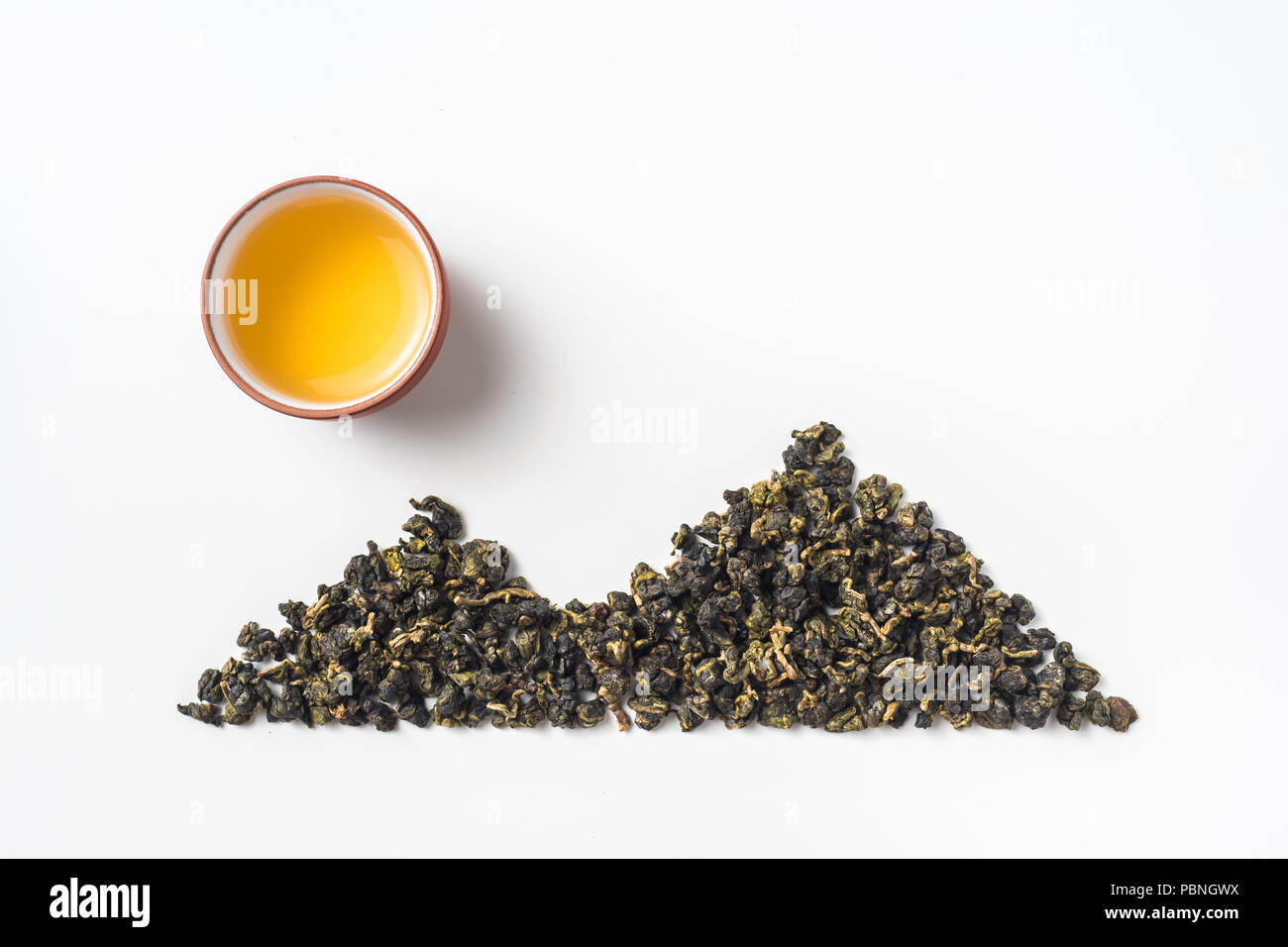 Asia culture and design concept - fresh taiwan oolong tea dry bud and chinese porcelain teacup layout like mountain & sun Stock Photo