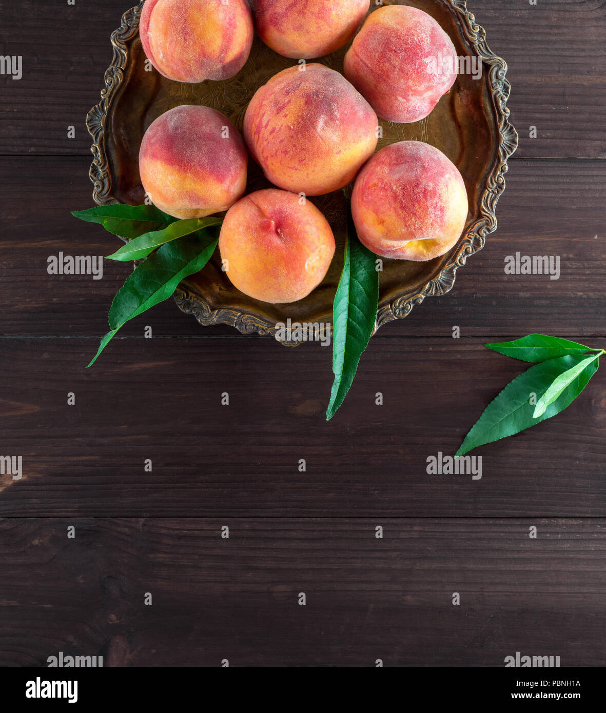 fresh ripe peaches in a round iron plate, top view, copy space Stock Photo