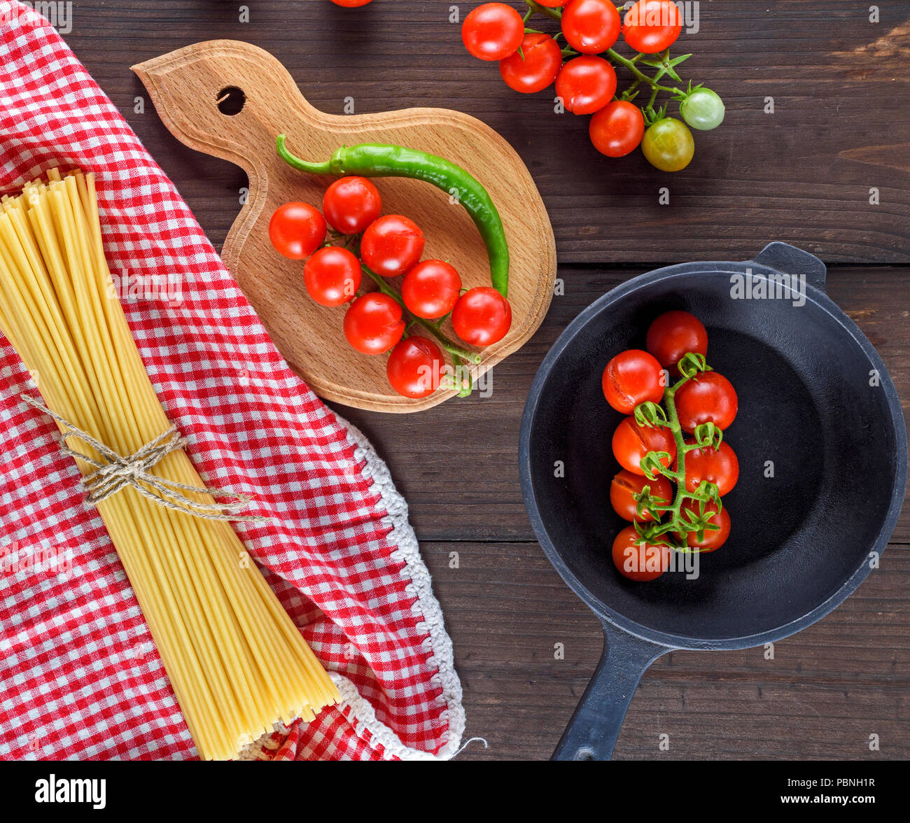 long pasta raw tied up with rope and ingredients for cooking food on a ...