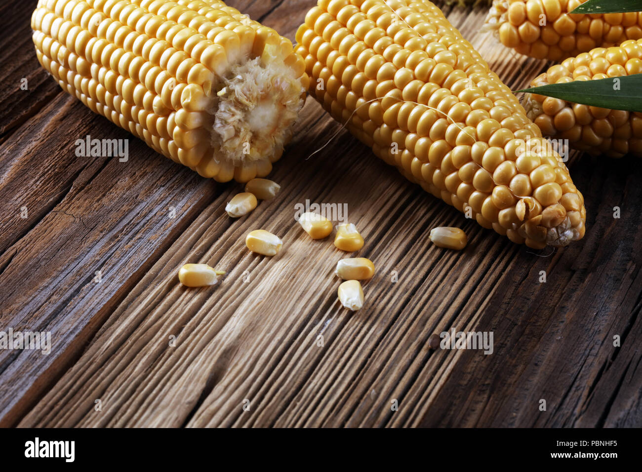 Fresh corn on cobs on rustic wooden table Stock Photo