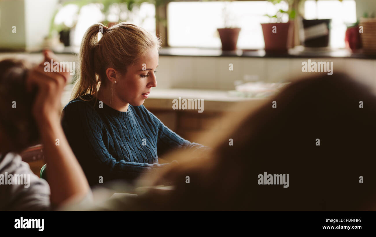 Portrait of beautiful teenage girl sitting at her desk and studying in ...