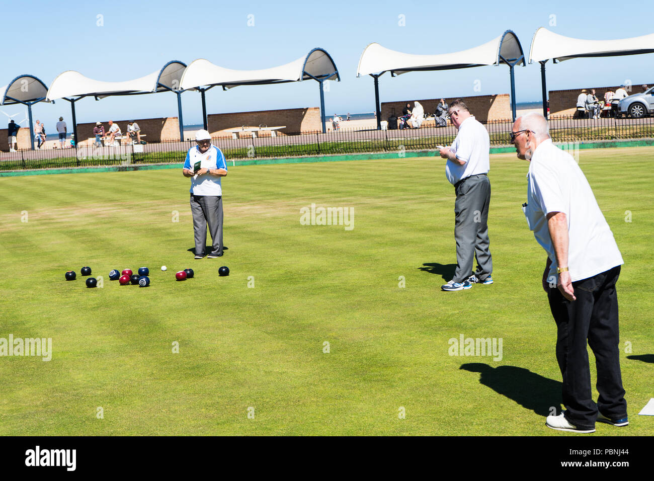 Men playing bowls at the bowling club Greate Yarmouth, England. Bowls