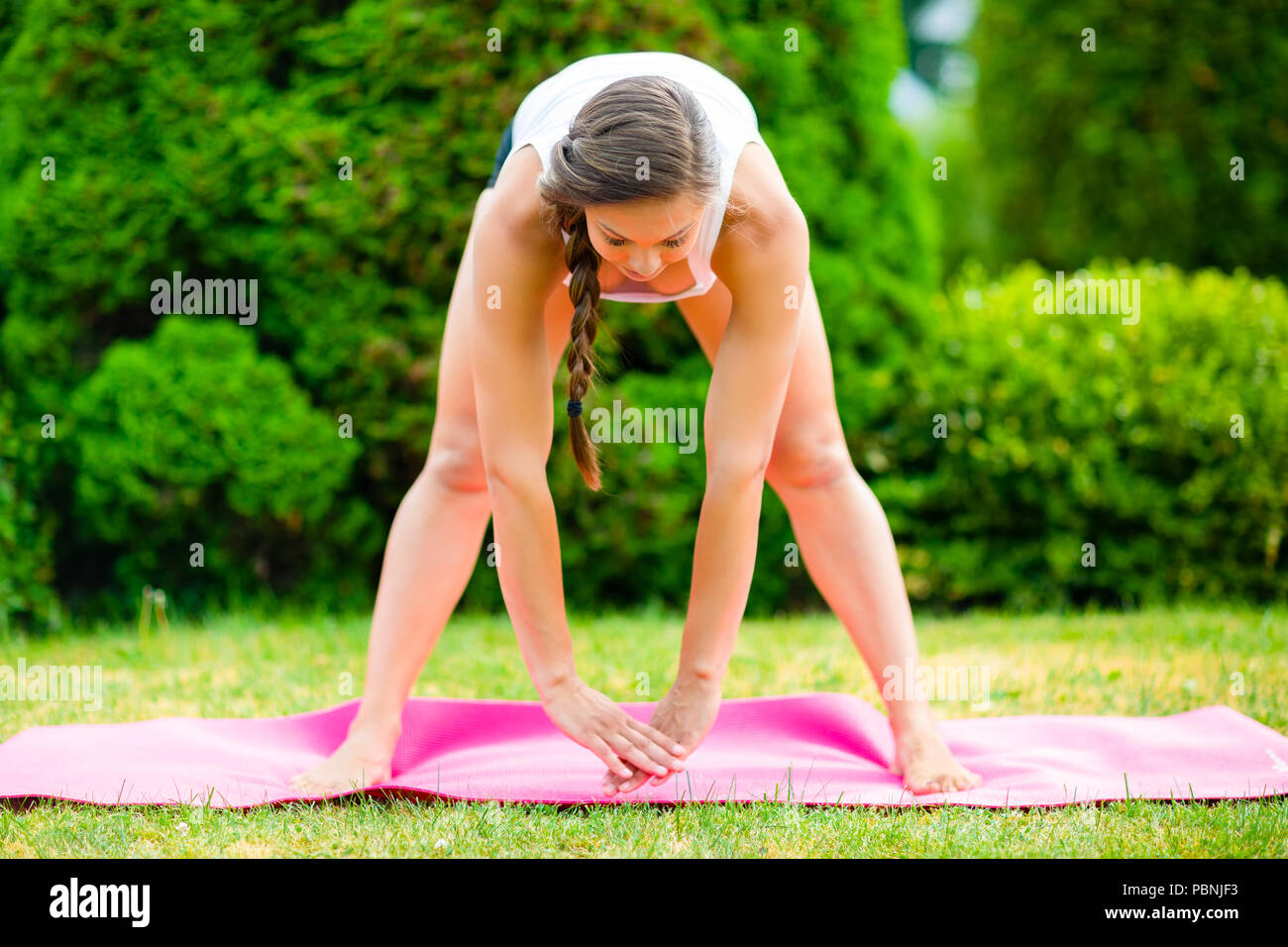 Woman doing yoga in park stock photo