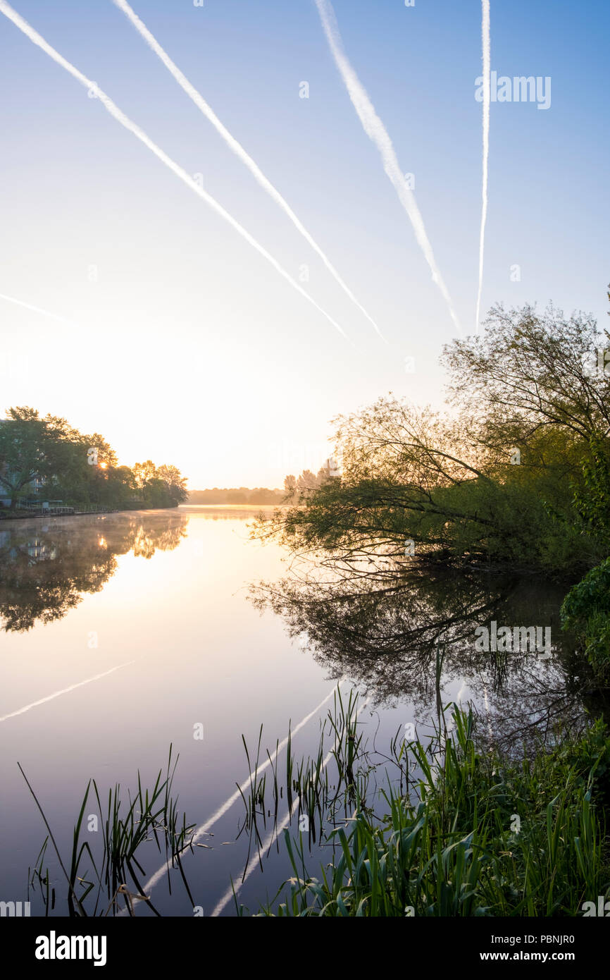 Aircraft contrails in the sky over the River Trent and the surrounding countryside at dawn, Nottinghamshire, England, UK Stock Photo