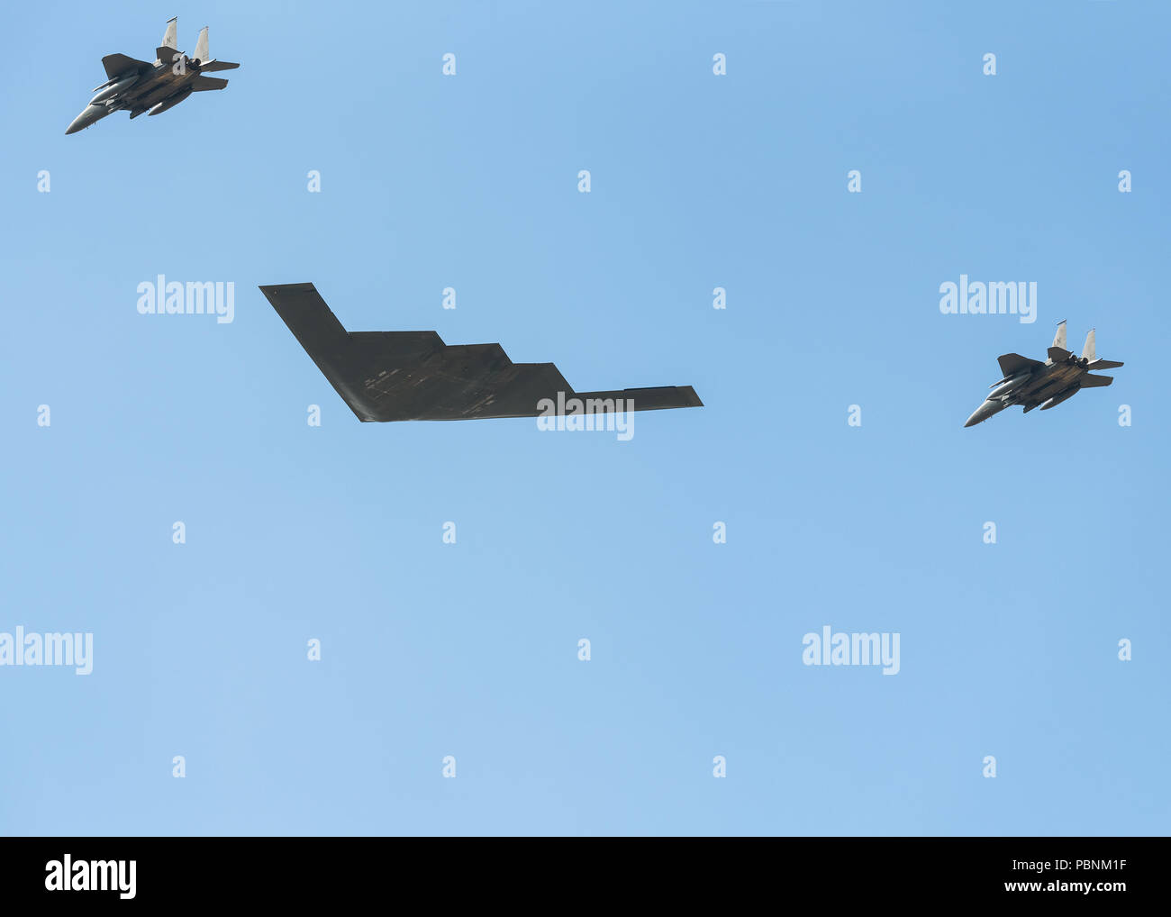 The Spirit of New York Northrop B-2 Stealth Bomber escorted by 2 RAF F-15 eagle fighter jets does a flyover display at RIAT Fairford 2018, UK. Stock Photo