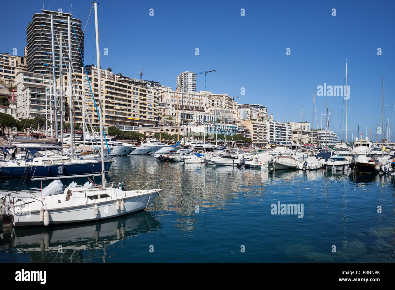 Monaco principality, Monte Carlo cityscape, boats, yachts and sailboats at Port Hercule on Mediterranean Sea Stock Photo