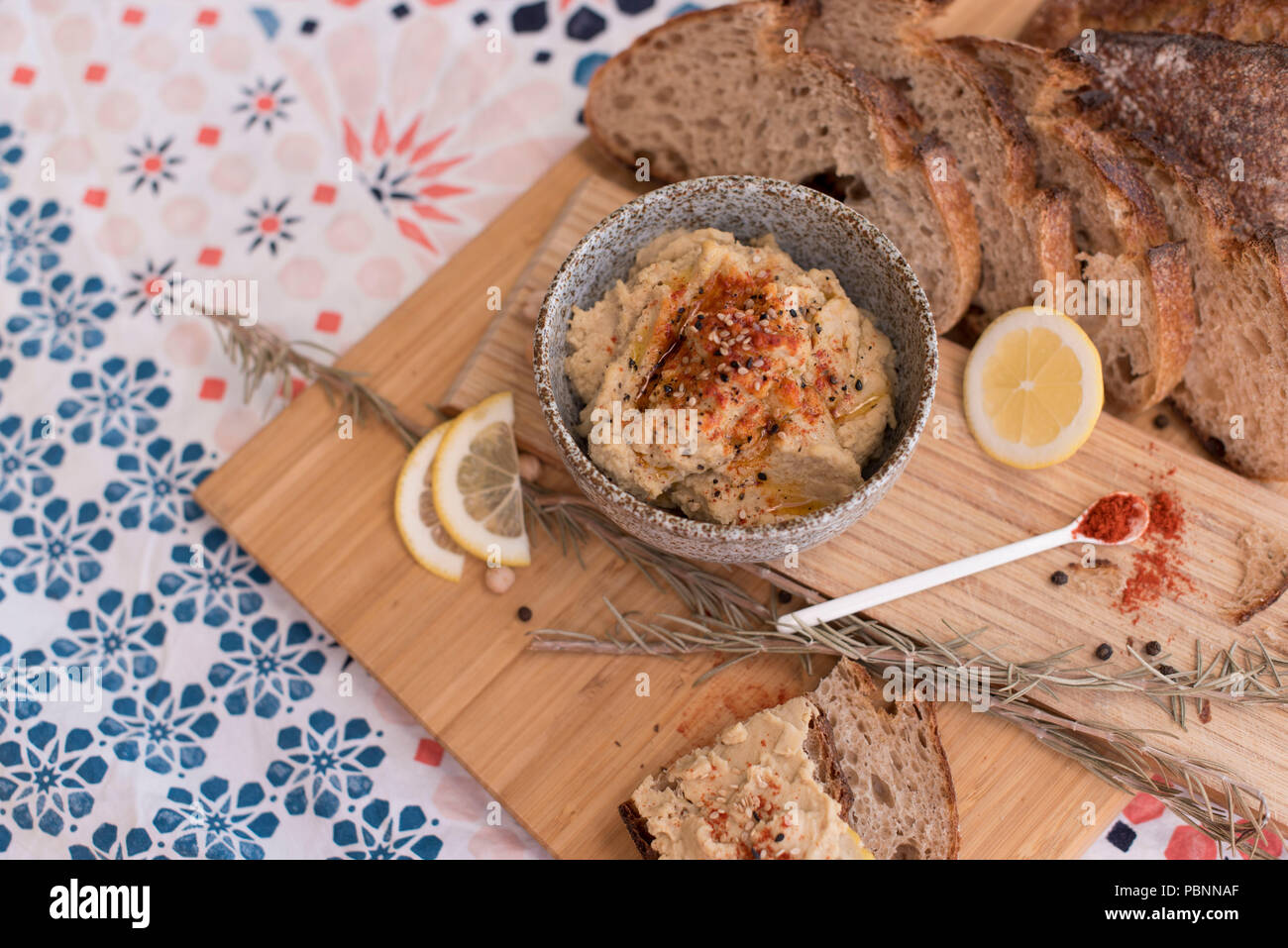 Hummus with wholemeal sourdough bread, paprika and lemon Stock Photo