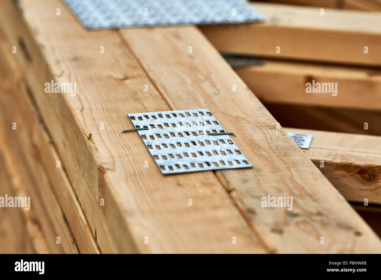 A close up of the metal connector plates on wood roofing trusses with shallow depth of field Stock Photo