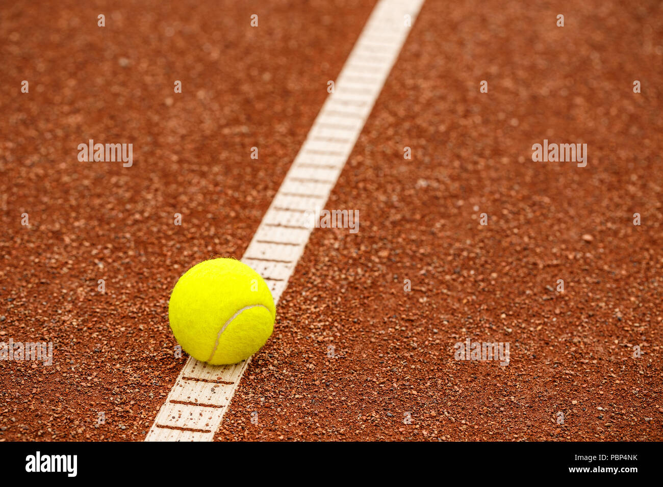 Sport item concept: Tennis balls at red court Stock Photo