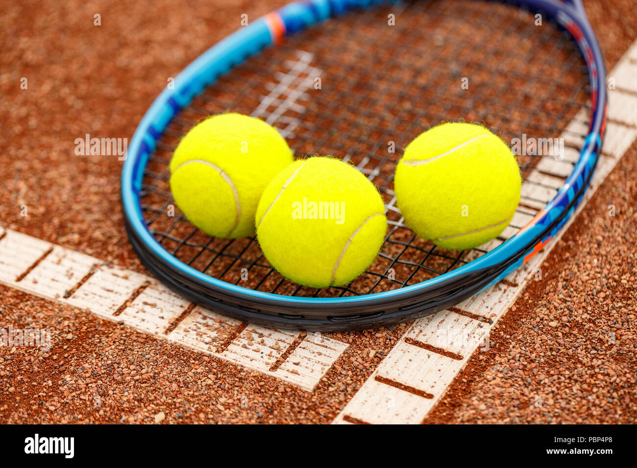 Close up view of tennis racket and balls on the clay tennis court Stock