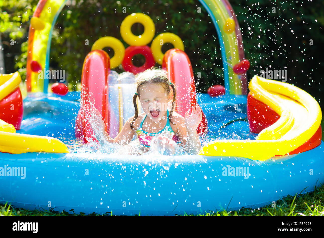 Child Playing In Inflatable Baby Pool Kids Swim Slide And Splash Colorful Garden Play Center Happy Little Girl Sliding Swimming With Water T Child Playing In Inflatable Baby Pool Kids Swim Slide And Splash Colorful Garden Play Center Happy Little Girl Sliding Swimming With Water T